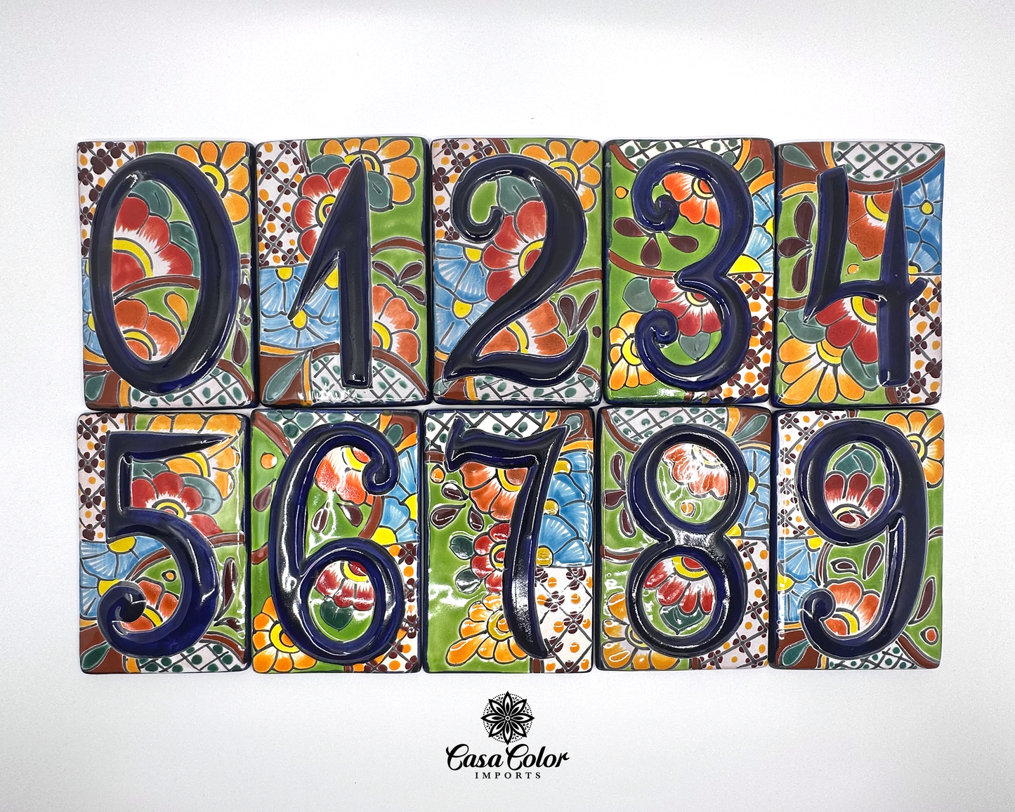 House of street numbers made of of handmade Mexican Talavera tile. The numbers are painted in a relief blue 0 to 1 with a background of flowers of different colors. The sizes are 4.5 by 3.5 inches.