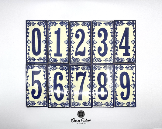Talavera handmade Mexican street numbers. The numbers are blue with blue decorations and a bone color as the background. The tiles are 5.75 inches by 3 inches wide. The finish is glossy. 