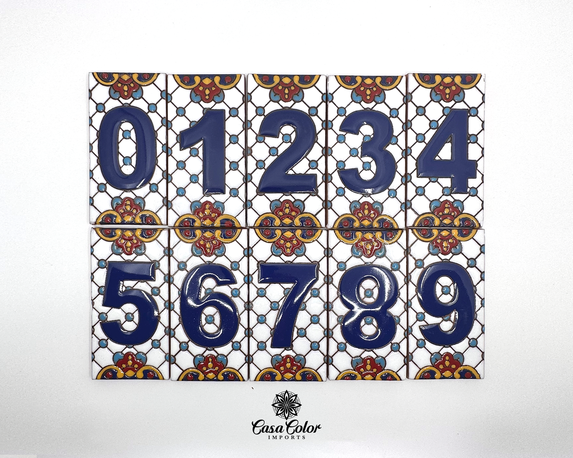 Talavera numbers with white background, The numbers are blue in a glossy relief surface. The tiles are decorated with blude and brown glossy relief flower figures. The tiles are handmade of ceramic. The sizes are 5.75 inches long and 3 inches wide.