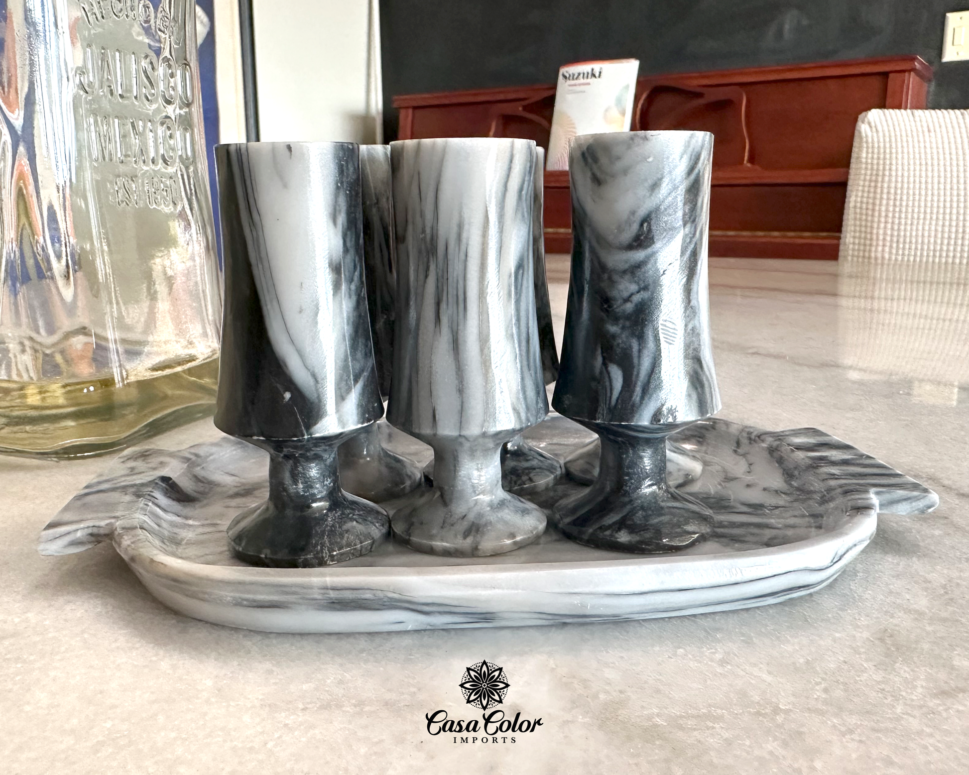 Set of six onyx stone shot glasses with steam on top of a trade also made of onyx. The natural color of the onyx is white with black veins around it. Every glass is 3.5 inch high and 1.5-inch in diameter.